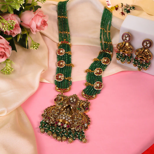 Matte Gold Polish Long Rajwadi Necklace Set with Crown-Shaped Doli Bride Pendant, Intricately Detailed with Ruby Stones, Kundan, and Bandai Work to Enhance Its Grandeur