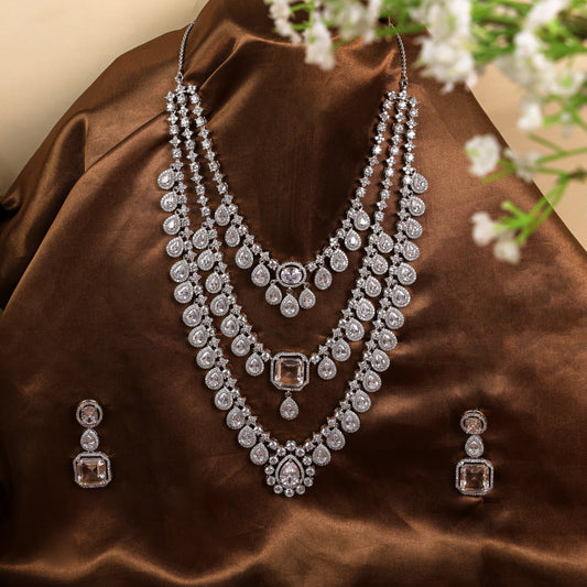 Graceful V-Shaped Design: Long 3-Line AD Necklace with American Diamonds and Pear-Shaped Stone at the Heart, Crafted in Brass Metal