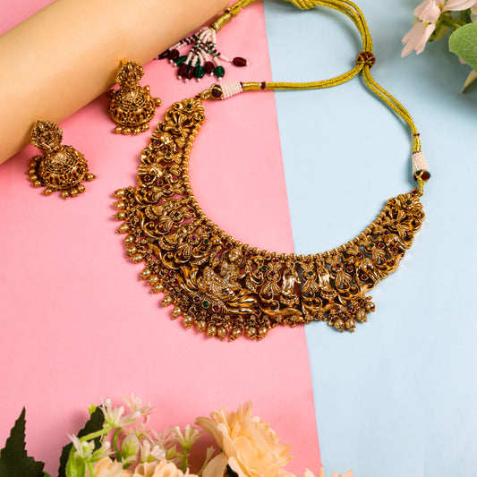 Antique Temple-Style Round Necklace featuring Goddess Lakshmi, Adorned with Ruby and Green Emerald Stones, Complemented by a Beautifully Designed Jhumka